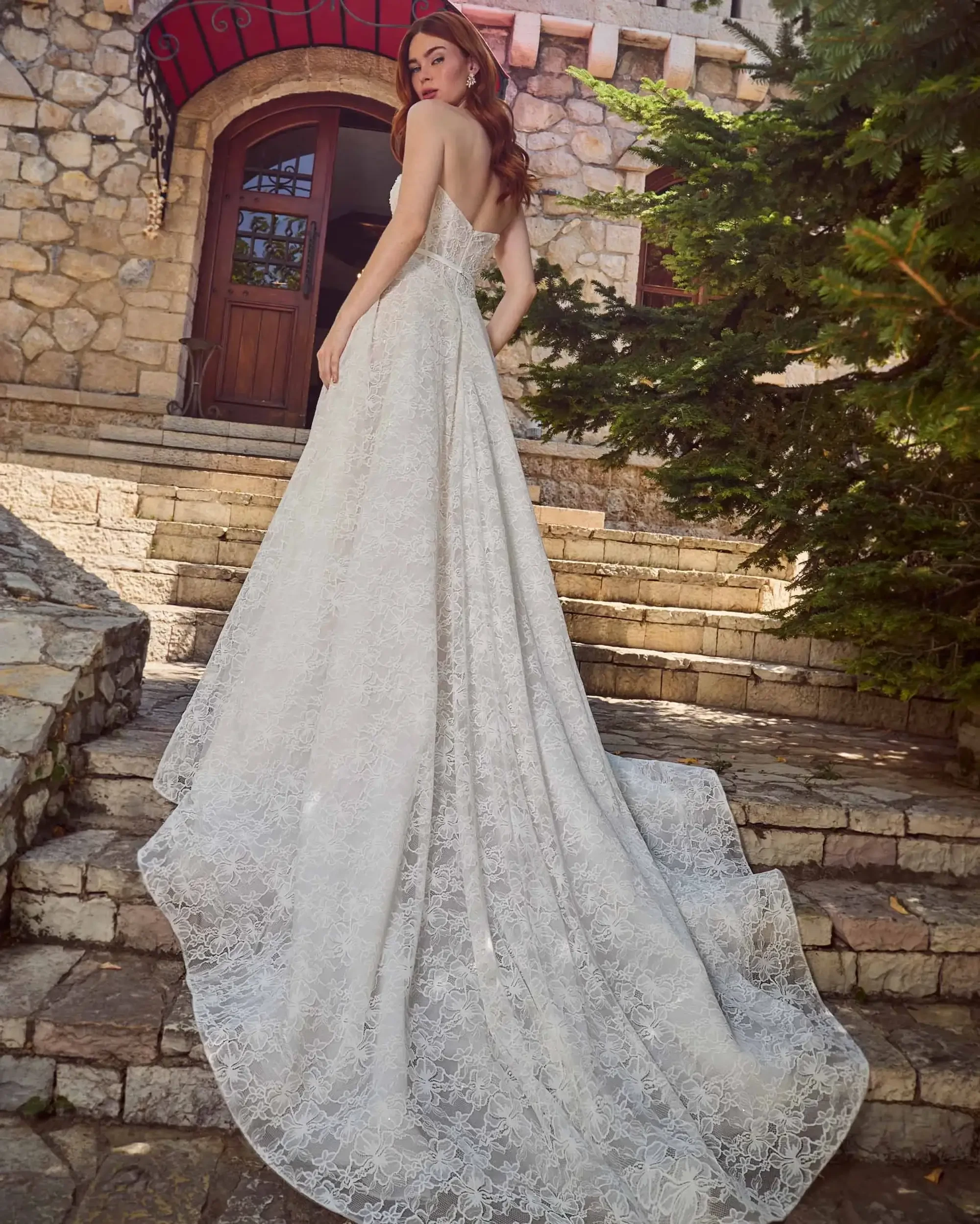 Model is wearing a strapless a-line wedding dress with floral lace