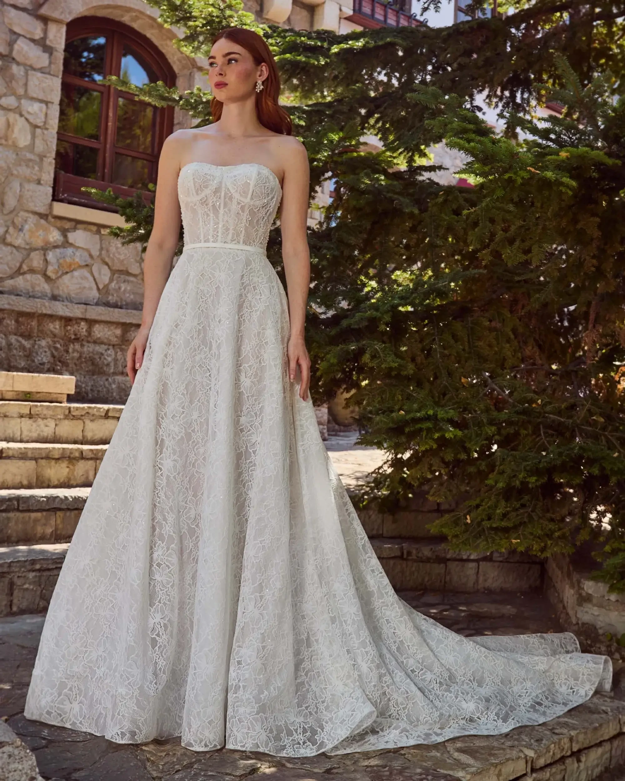 Model is wearing a strapless a-line wedding dress with floral lace