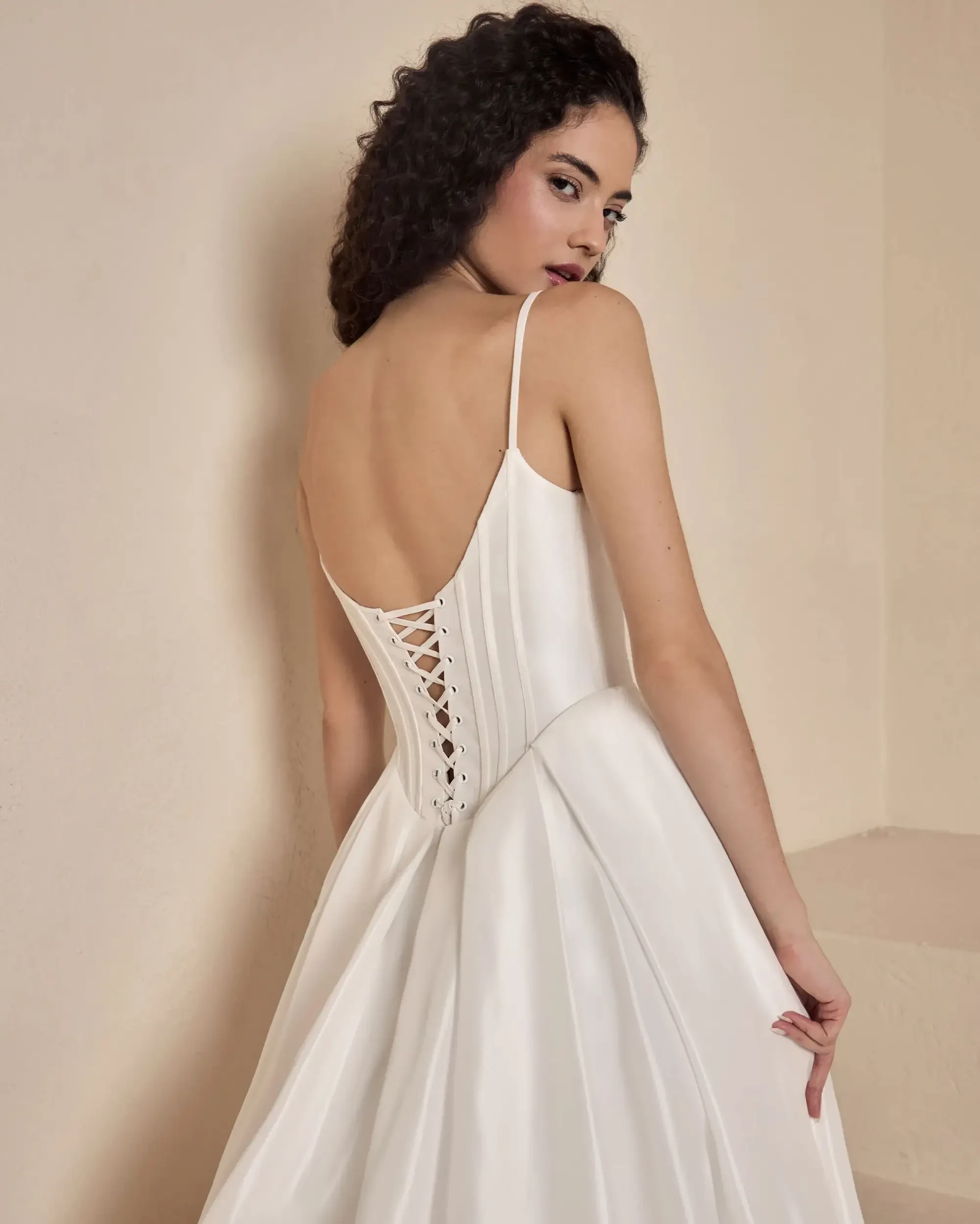 Model is wearing an a-line wedding dress with a square neckline